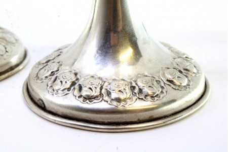 Castiçais em prata com relevos florais na base e friso