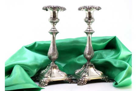 Castiçais em prata com fuste relevado com folhas de acanto, assentes sobre base 