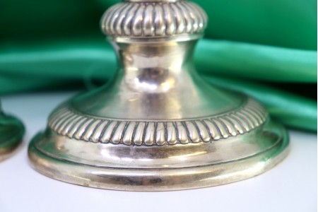 Castiçais em prata com relevos canelados em bases circulares.