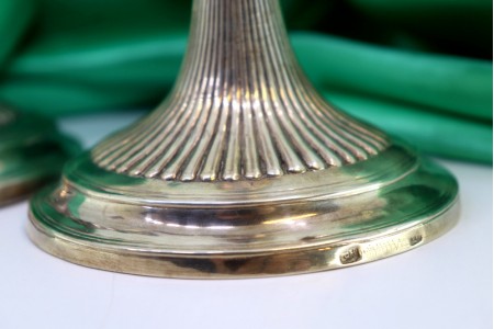 Castiçais em prata canelados com relevos e bases circulares frisadas.