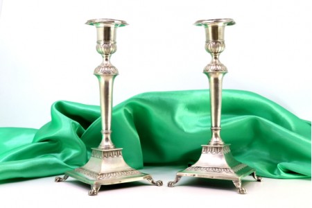 Castiçais em prata com relevos e assentes em bases quadradas com quatro pés 