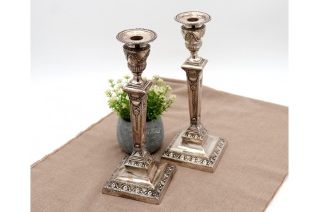 Castiçais em prata com relevos, grinaldas, laços e fustes em forma de obelisco 