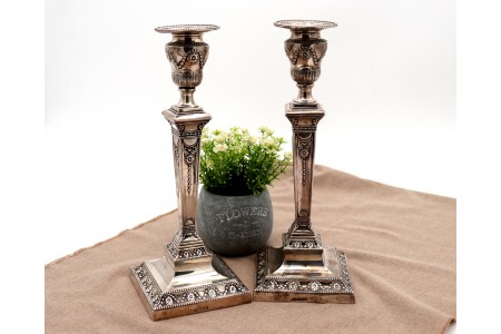 Castiçais em prata com relevos, grinaldas, laços e fustes em forma de obelisco 