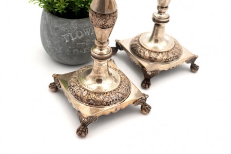 Castiçais de prata com fustes torneados com motivos florais relevados e folhas 