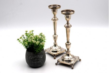 Castiçais em prata com frisos assentes em bases quadradas e com quatro pés 
