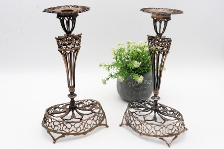 Castiçais de prata recortada assentes em bases de formato elíptico.