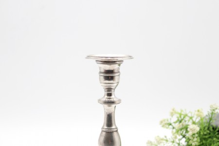 Castiçal solitário baixo em prata lisa com fuste torneado e base circular.