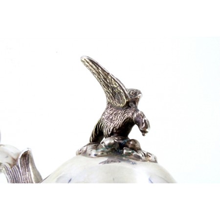  Chaleira em prata com motivos florais relevados envolvendo cartelas para monogramas, pomo na tampa em figura de águia e assente em quatro pés recortados.
