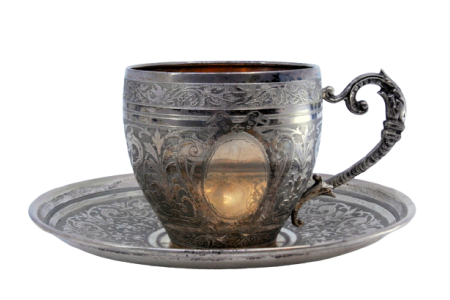 Chávena com pires em prata nielada com motivos florais gravados envolvendo cartela para monograma.