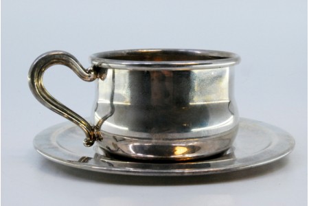 Chávena com pires em prata lisa e asa relevada.