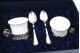  Chávenas em porcelana com suportes em prata e duas colheres de café com estojo próprio.