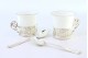  Chávenas em porcelana com suportes em prata e duas colheres de café com estojo próprio.