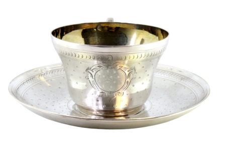 Chávena e pires em prata guilhochada envolvendo cartelas para monogramas e interior dourado.