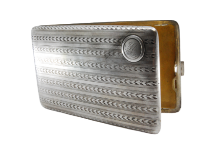 Cigarreira em prata com bandas espinhadas ao longo envolvendo cartela para para monograma, interior dourado e tampa basculante.
