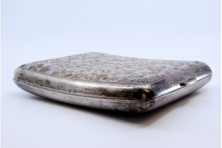 Cigarreira de prata com flores gravadas em formato curvo, dois suportes para cigarros no interior e tampa basculante.