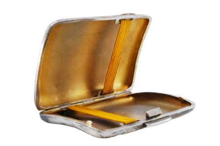 Cigarreira em prata de formato curvo com gravados guilhochados, dourado no interior e tampa basculante.