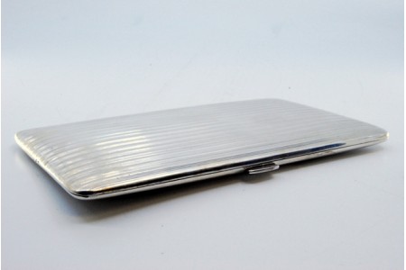 Cigarreira em prata com bandas caneladas em ambos os lados e tampa basculante.