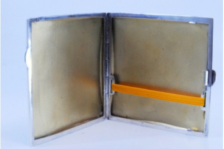 Cigarreira em prata guilhochada envolvendo cartela para monograma com interior dourado e tampa basculante.