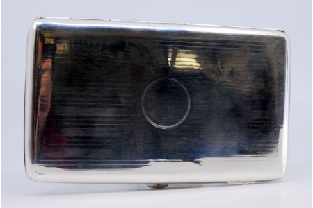 Cigarreira em prata guilhochada em ambos os lados envolvendo cartela para monograma e tampa basculante.