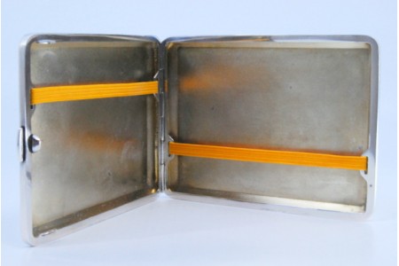 Cigarreira em prata com gravados envolvendo cartela para monograma, interior com suporte para os cigarros e tampa basculante.