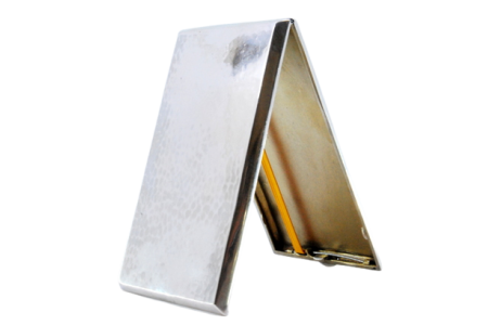 Cigarreira em prata martelada com interior dourado, duas fitas para suporte dos cigarros e tampa basculante.