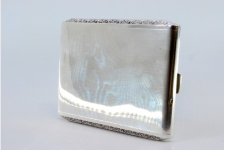 Cigarreira em prata lisa com frisos revelados na envolvência e tampa basculante.