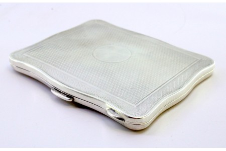  Cigarreira em prata guilhochada com frisos na envolvência ondeada e interior dourado com tampa basculante,  mola no fecho.