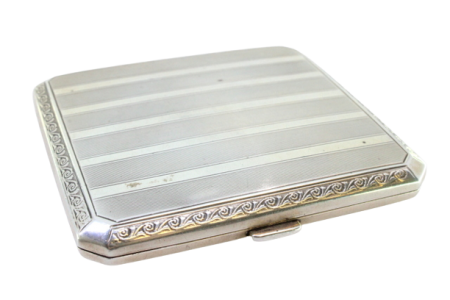 Cigarreira em prata guilhochada com os cantos chanfrados, bandas ao alto com interior dourado e tampa basculante.