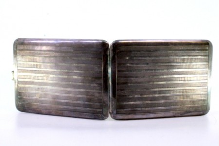 Cigarreira em prata com bandas guilhochadas ao longo com tampa basculante e interior dourado.
