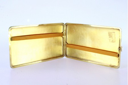 Cigarreira em prata com bandas gravadas ao longo envolvendo cartela para monograma e interior dourado.