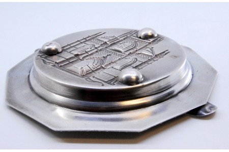 Cinzeiro em prata com relevo do mosteiro da Batalha no centro e frisos na envolvência.