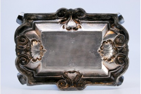 Cinzeiro em prata com brasão de D. João V relevado no centro.