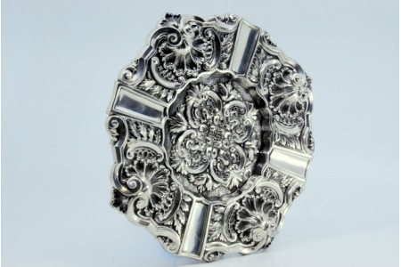 Cinzeiro em prata com relevos concheados e aplicações para apoio dos cigarros.