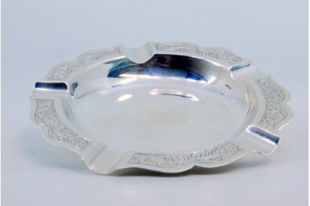 Cinzeiro em prata com motivos vegetalistas gravados e cinco suportes para cigarros.