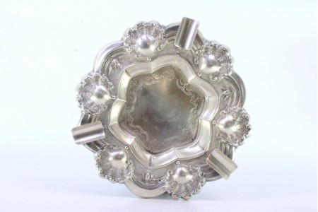 Cinzeiro em prata relevada com conchas e gravados no centro, com três apoios de cigarros.