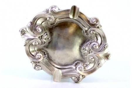 Cinzeiro em prata com relevos concheados e dois suportes para cigarros.