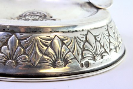 Cinzeiro em prata redondo com brasão ao centro e friso envolvente, enchimento na base.