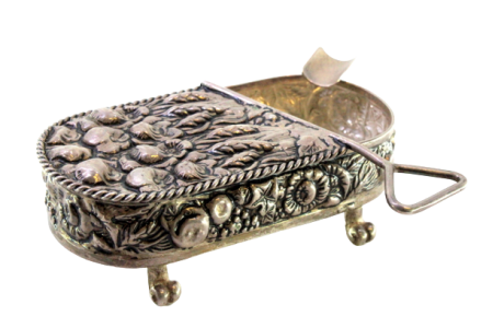 Cinzeiro em prata com forma de lata conserva com motivos florais revelados e assente em quatro pés retorcidos.