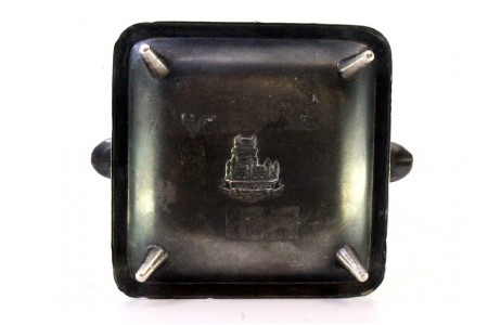 Cinzeiro em prata com relevos alusivos à torre de Belém no centro fosco, dois suportes para cigarros e assente em quatro pés.