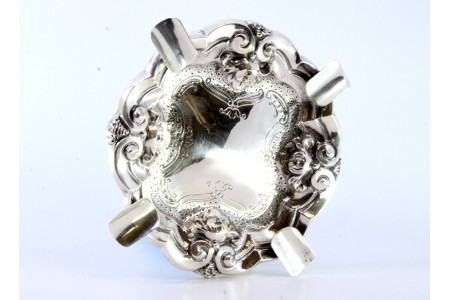 Cinzeiro em prata com relevos e gravados, quatro apoios para cigarros.