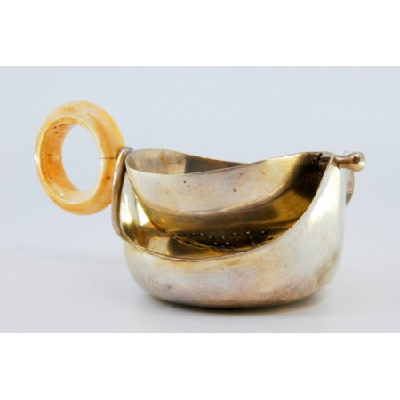 Coador de chá em prata dourada com pega em matéria óssea.