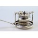 Coador de chá em prata com depósito em forma de taça ondeada e cabo com relevos concheados.