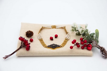  Colar de ouro com segmentos alternados com pérolas de cultura e medalhão central em prata com lascas de diamante e diamante em talhe brilhante no centro.