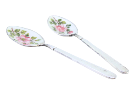 Conjunto de duas colheres de chá em prata com concha esmaltada e flores relevadas nos cabos.