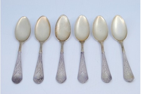 Conjunto de seis colheres de café em prata com conchas douradas e cabos relevados.