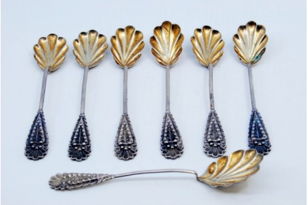 Conjunto de seis colheres de café e pá de açúcar com conchas em forma de folhas douradas e cabos relevados.