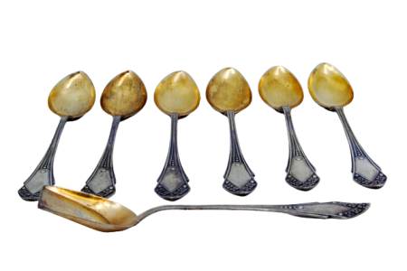 Conjunto de seis colheres de café e pá de açúcar em prata com conchas douradas e relevos nos cabos.