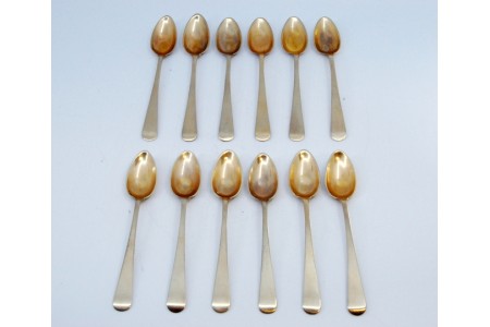 Conjunto de doze colheres de chá em prata lisa e conchas douradas.