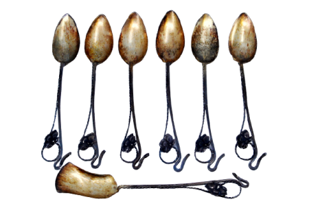 Conjunto de seis colheres de café e pá de açúcar em prata recortada e conchas douradas.