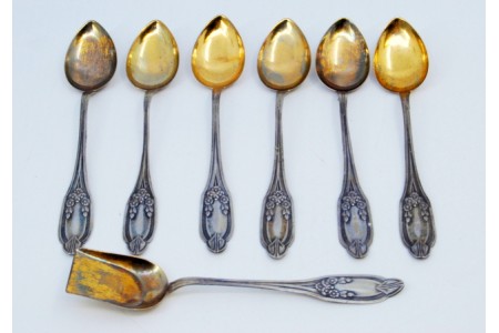  Conjunto de seis colheres de café em prata e pá de açúcar com as conchas douradas e cabos relevados.
